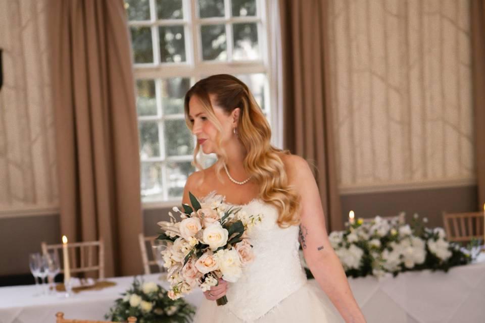 A bride holding her bouquet in soft window light