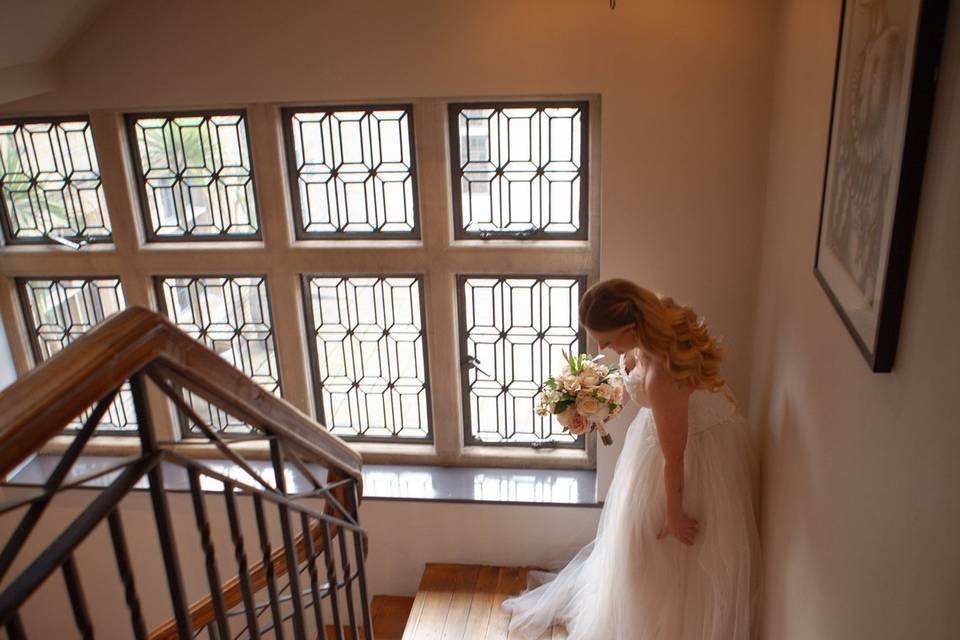 A bride beside an elegant staircase